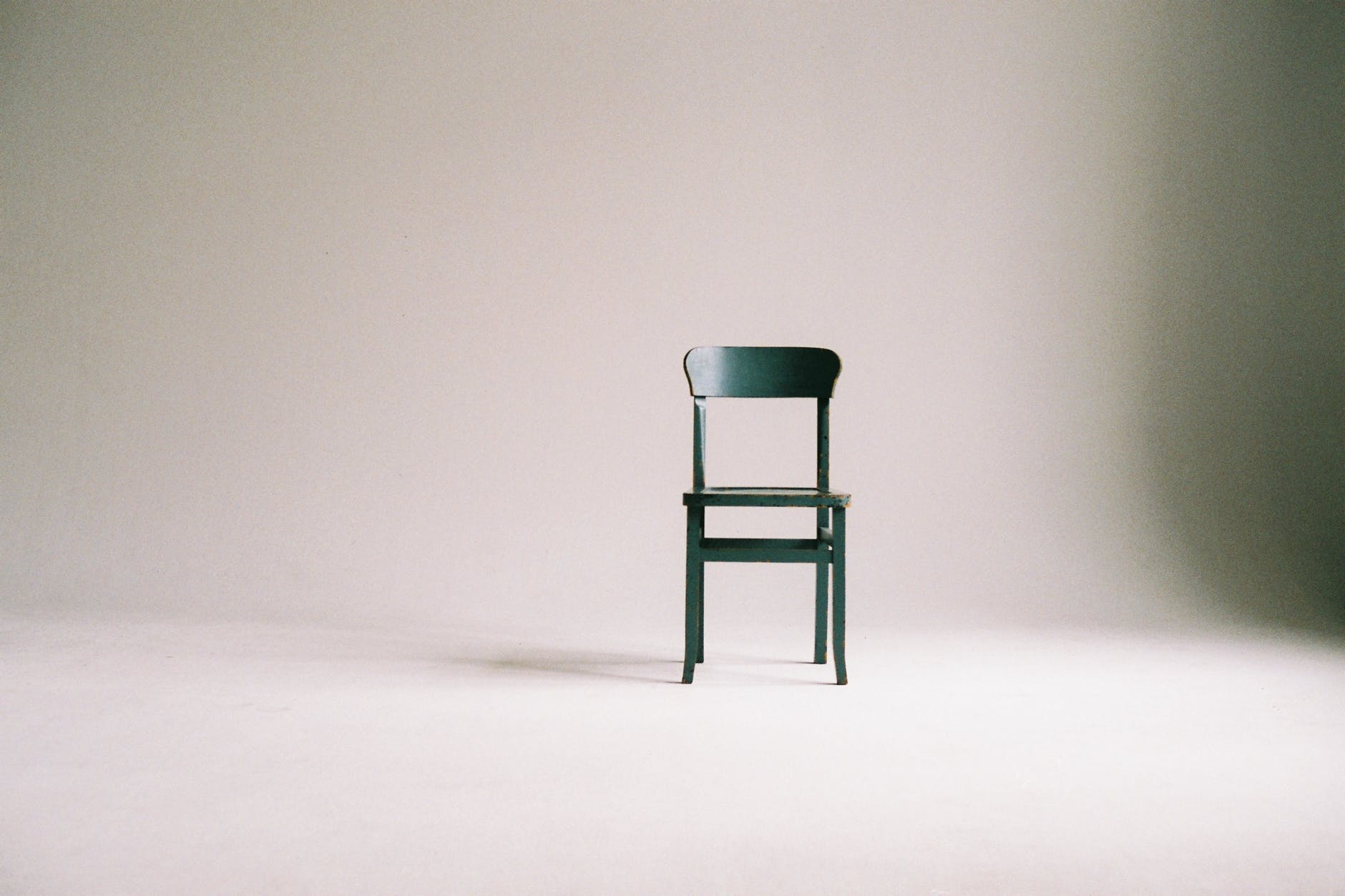 green wooden chair on white surface