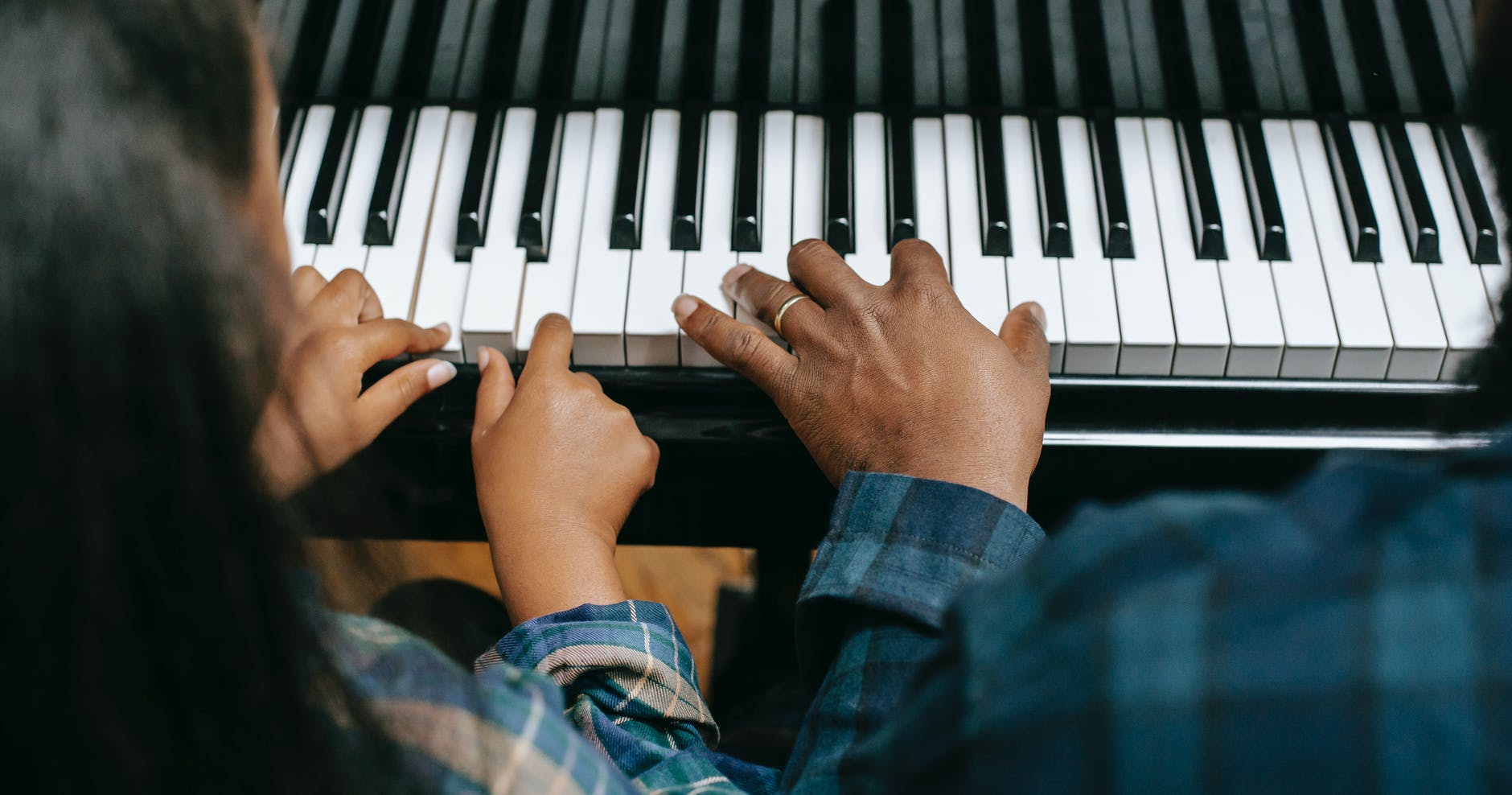 black father playing piano with daughter